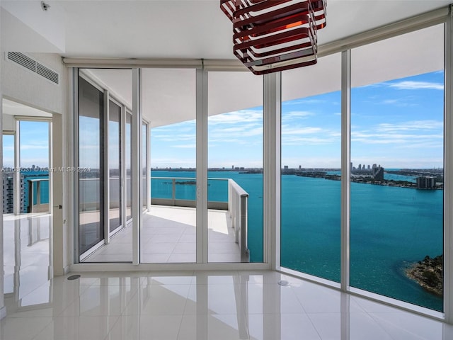 interior space featuring a water view and light tile patterned floors