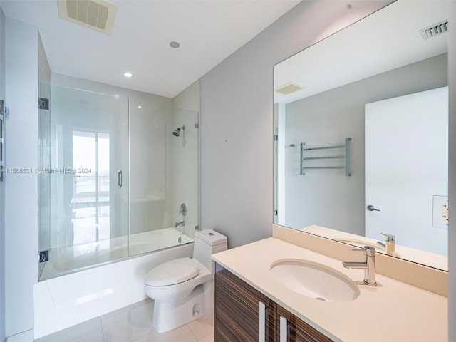 full bathroom with vanity, toilet, tile patterned flooring, and bath / shower combo with glass door