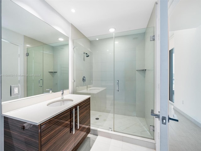 bathroom featuring vanity, walk in shower, and tile patterned flooring