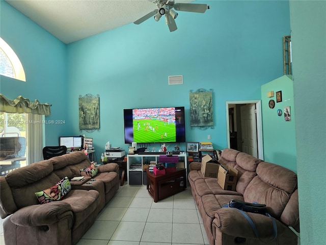 tiled living room featuring a healthy amount of sunlight, a high ceiling, and ceiling fan