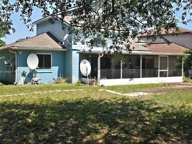 rear view of property featuring a sunroom and a lawn