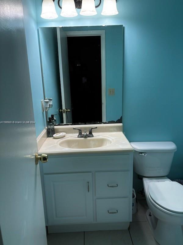 bathroom featuring tile patterned flooring, toilet, and vanity