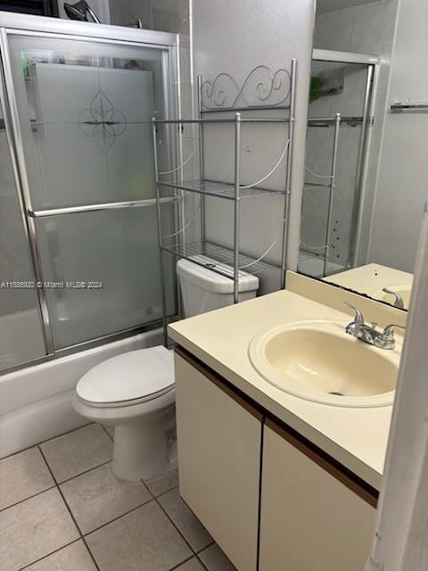 full bathroom featuring vanity, tile patterned floors, enclosed tub / shower combo, and toilet