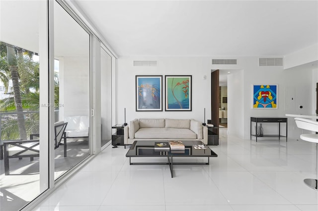 living room featuring a healthy amount of sunlight, floor to ceiling windows, and light tile flooring