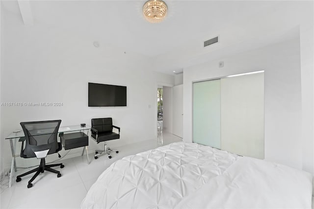 bedroom with a closet and light tile floors