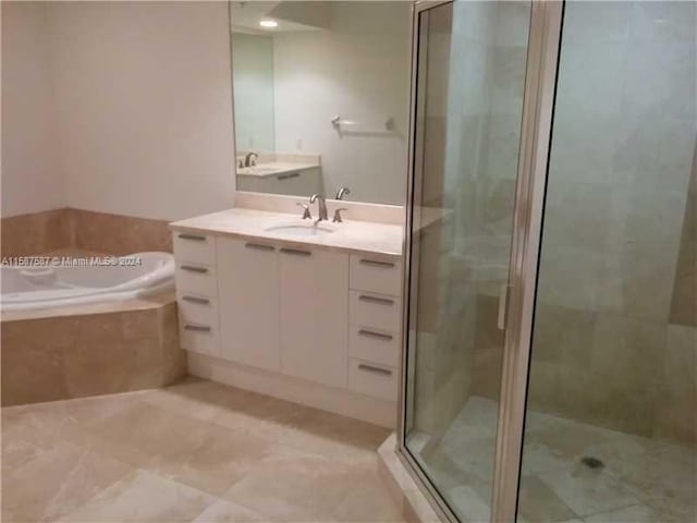 bathroom featuring plus walk in shower, tile flooring, and vanity