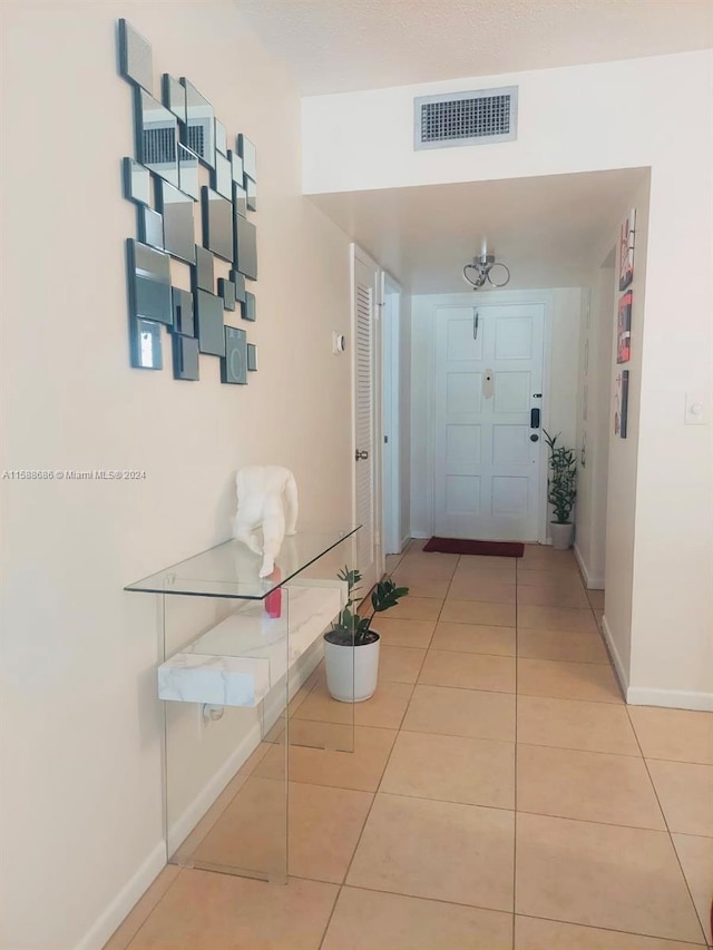 hall featuring light tile flooring