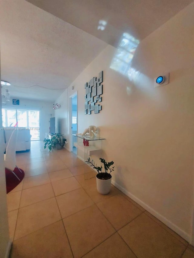 corridor with tile flooring and a textured ceiling