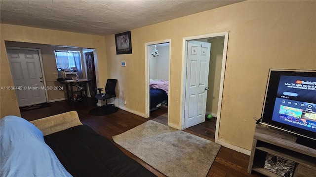 bedroom featuring dark wood-type flooring and a textured ceiling