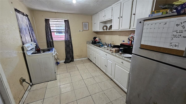 kitchen featuring white electric range, stainless steel fridge, a textured ceiling, light tile floors, and white cabinets