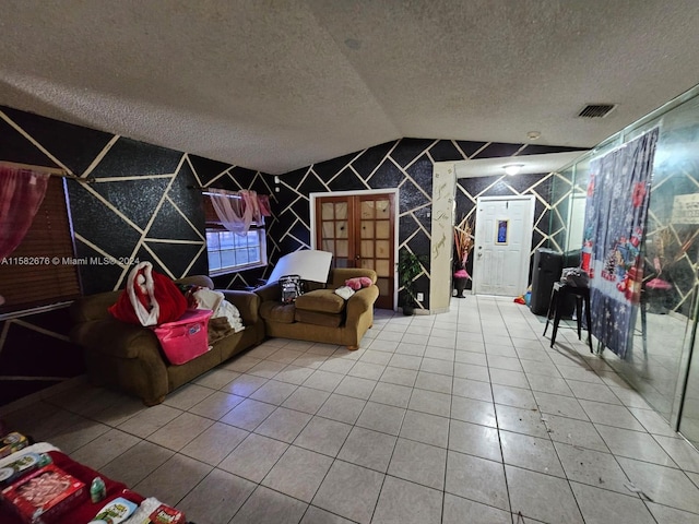 rec room featuring a textured ceiling, lofted ceiling, and tile patterned flooring