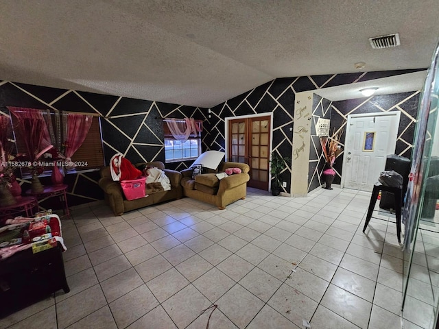 game room with a textured ceiling, tile patterned flooring, and vaulted ceiling