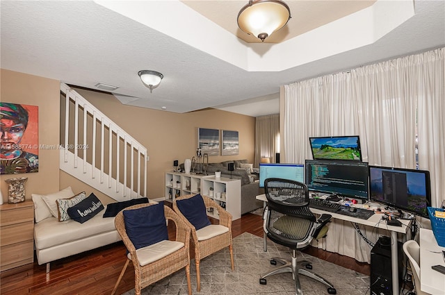 office area with hardwood / wood-style floors, a textured ceiling, and a raised ceiling