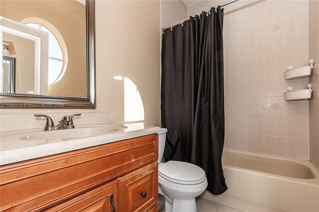 full bathroom featuring shower / bathtub combination with curtain, tile flooring, toilet, and vanity with extensive cabinet space