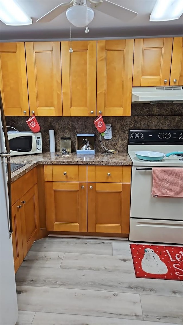 kitchen featuring white appliances, stone counters, backsplash, light hardwood / wood-style floors, and ceiling fan