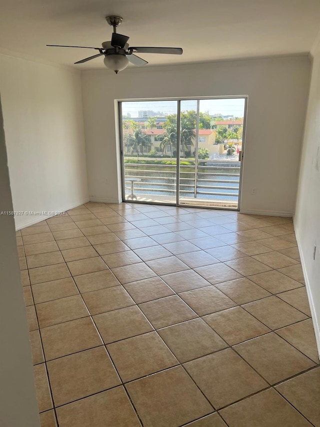 empty room featuring ceiling fan and light tile flooring