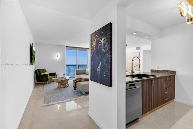 kitchen featuring stainless steel dishwasher, dark brown cabinetry, floor to ceiling windows, sink, and light tile floors