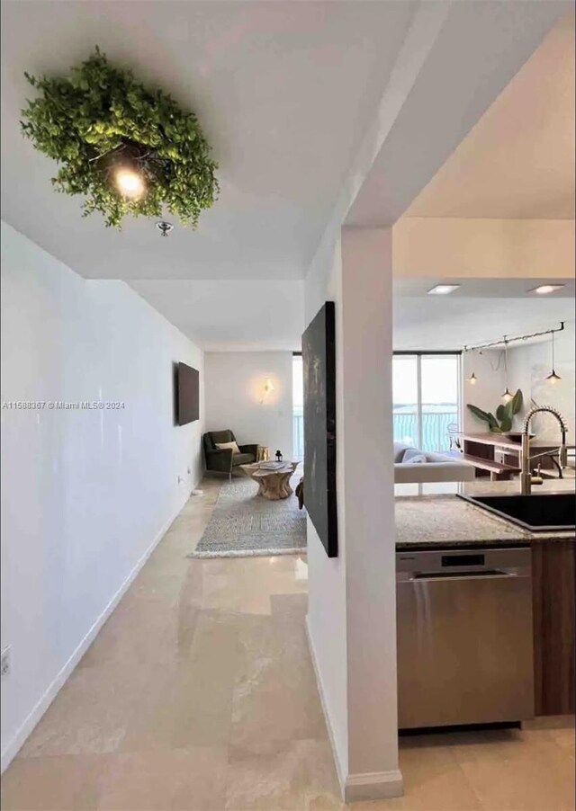 corridor featuring sink and light tile floors