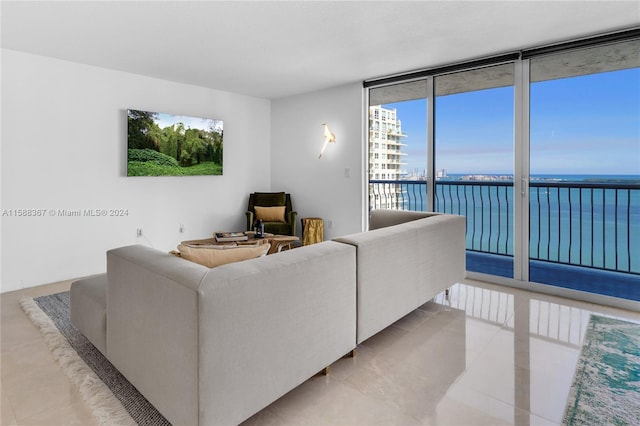 living room with a water view, tile flooring, and a wall of windows