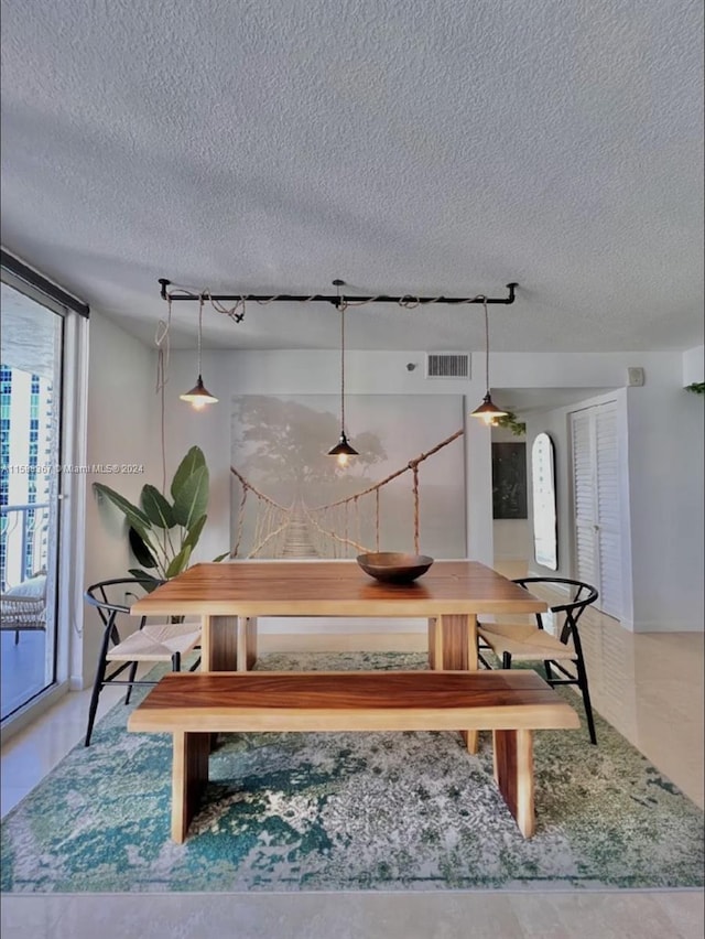 tiled dining room featuring a textured ceiling