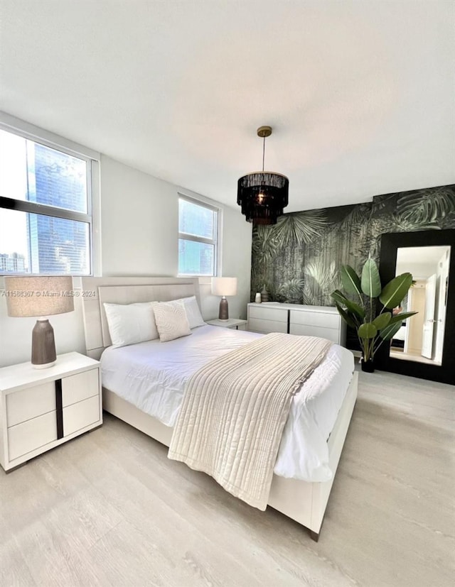 bedroom featuring a chandelier and light hardwood / wood-style floors