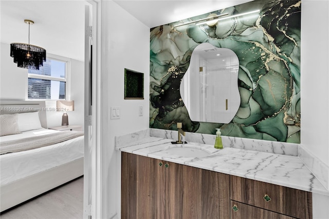 bathroom with hardwood / wood-style floors, oversized vanity, and a chandelier