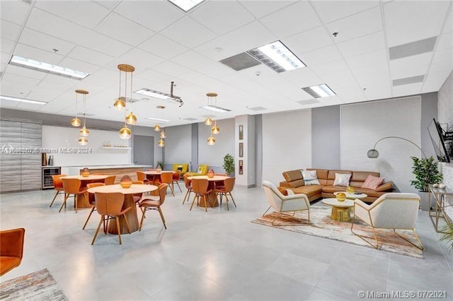 tiled dining room with a drop ceiling