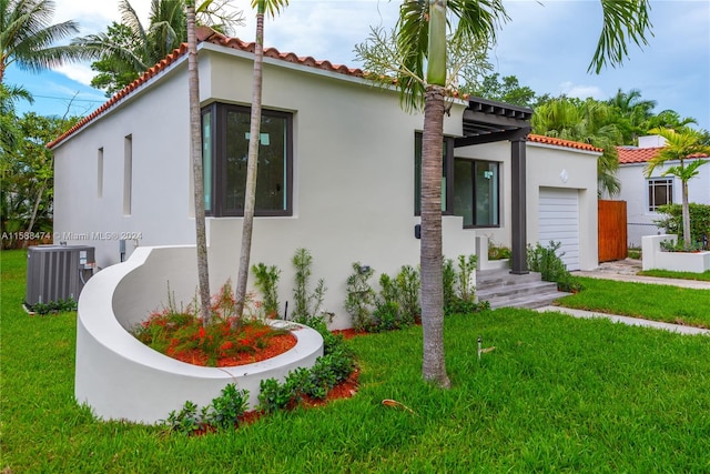 mediterranean / spanish home featuring a front lawn and central AC unit