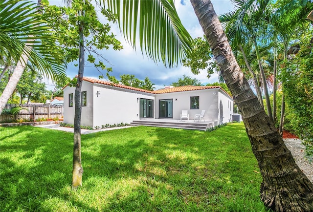 rear view of house with a yard and central AC unit