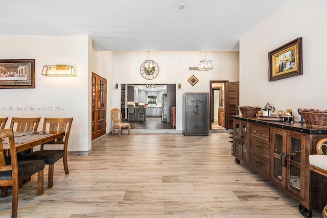 hallway featuring a chandelier and light wood-style flooring