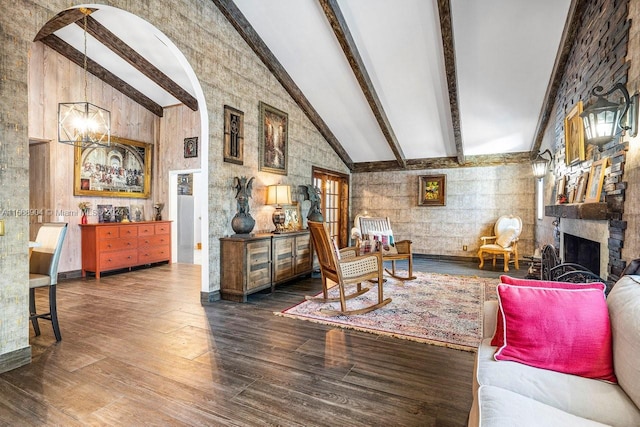 sitting room featuring a large fireplace, high vaulted ceiling, beamed ceiling, and wood finished floors