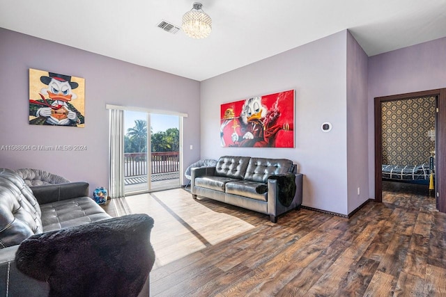 living room featuring baseboards, visible vents, and wood finished floors