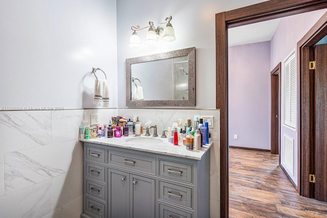 bathroom featuring tile walls, vanity, and wood finished floors