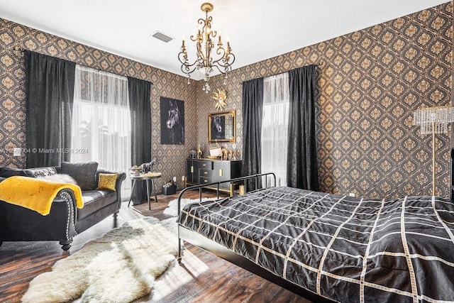 bedroom featuring wood-type flooring and an inviting chandelier