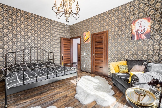 bedroom featuring a chandelier, wood finished floors, and wallpapered walls