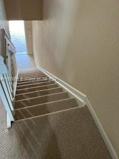 stairway with carpet flooring and baseboards