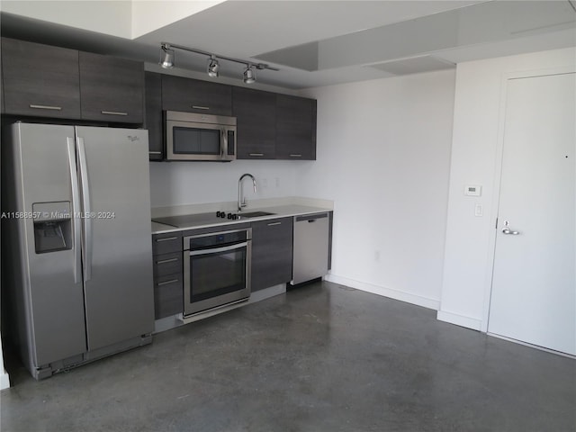 kitchen featuring stainless steel appliances, track lighting, and sink