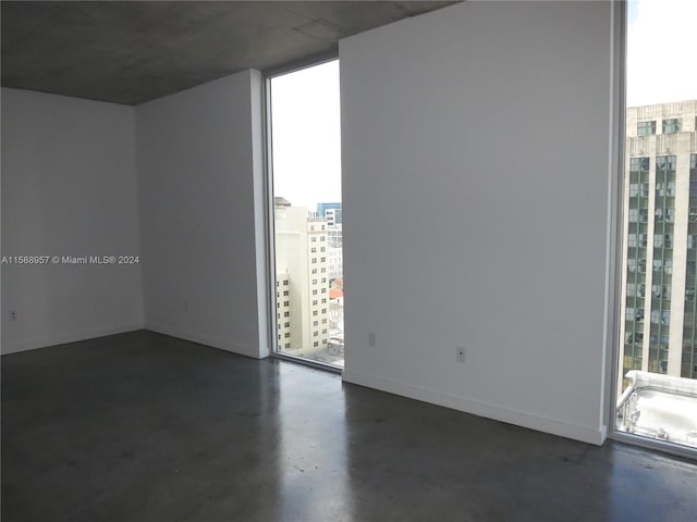 unfurnished room featuring a wall of windows