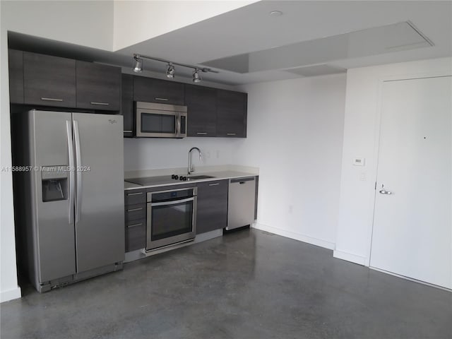 kitchen with track lighting, appliances with stainless steel finishes, and sink