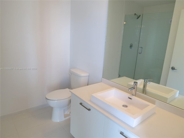 bathroom featuring tile floors, a shower with shower door, vanity, and toilet