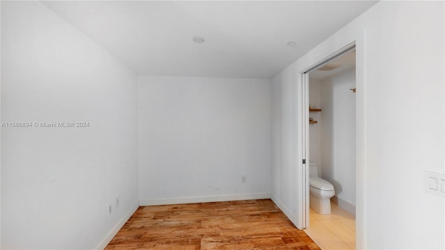 unfurnished bedroom with connected bathroom and tile floors