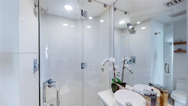 bathroom featuring a shower with door and toilet