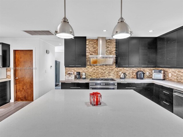 kitchen with sink, appliances with stainless steel finishes, backsplash, a center island, and decorative light fixtures