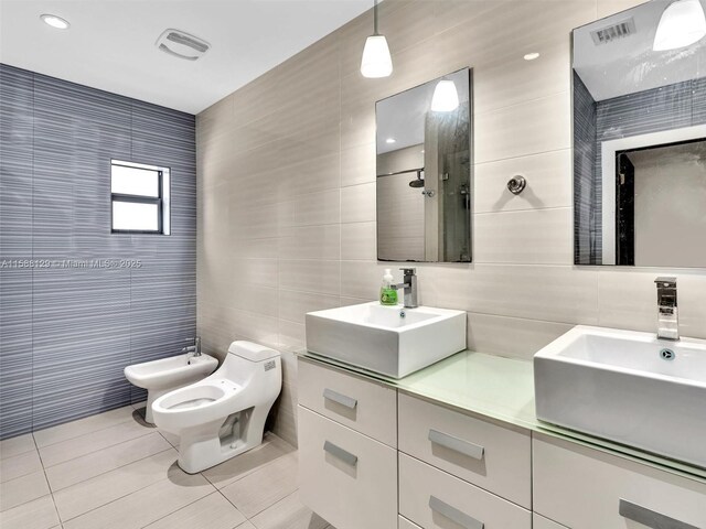 bathroom featuring a bidet, tile patterned floors, toilet, and tile walls