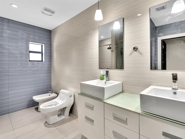 bathroom with a bidet, a sink, and tile walls