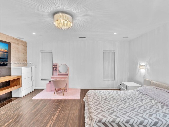 bedroom with hardwood / wood-style flooring and a notable chandelier