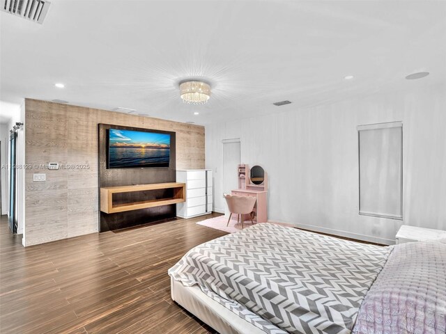 bedroom featuring dark wood-type flooring and an inviting chandelier