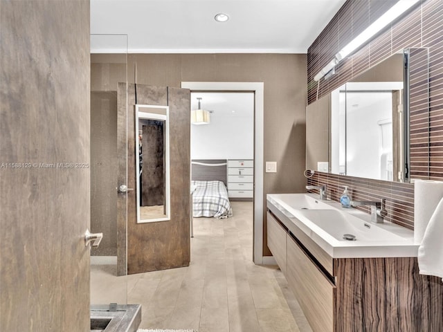 bathroom featuring double vanity, decorative backsplash, and a sink