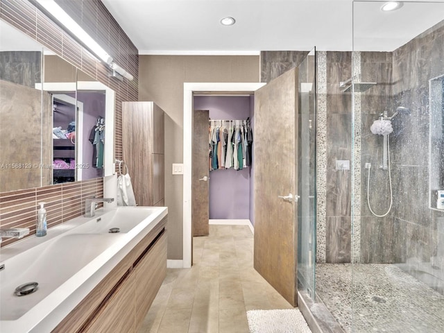 ensuite bathroom with tasteful backsplash, a stall shower, connected bathroom, vanity, and tile patterned flooring