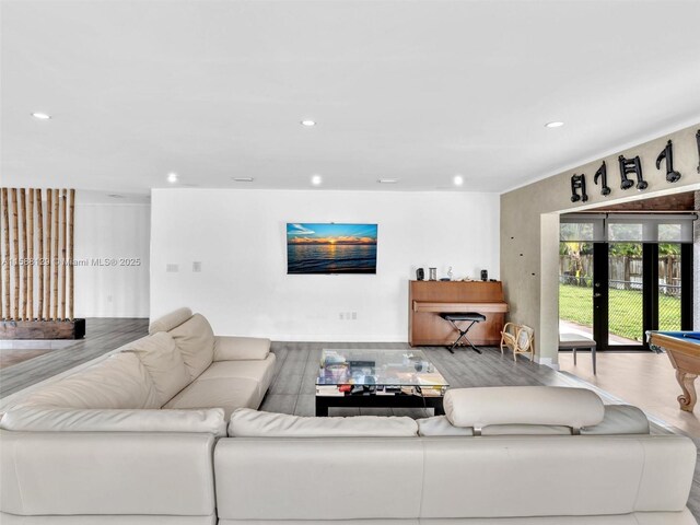 living room with hardwood / wood-style flooring, pool table, and french doors